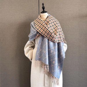 Detail of soft cashmere-like scarf with letter B jacquard and fringe edges