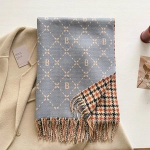 Detail of cashmere scarf with letter B embroidery and fringe on wool coat