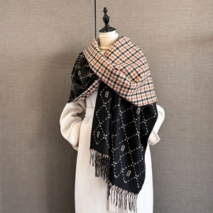 Macro detail of thick winter scarf featuring B letters, houndstooth patterns and tassels
