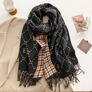 Detail of soft faux cashmere scarf featuring B-letter pattern and classic tassels