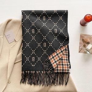 Close-up of thick scarf showing double-sided houndstooth and letter B patterns with tassels