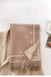 Detail of honeybee jacquard pattern and fringes on a thick plaid winter scarf
