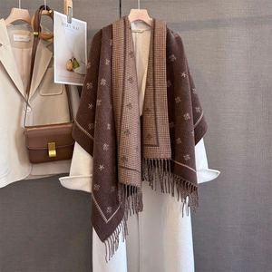 Winter scarf with bee embroidery and houndstooth pattern draped on a white coat