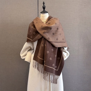 Detailed view of winter scarf featuring bee embroidery, houndstooth pattern and long tassels