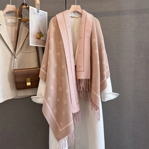 Thick winter scarf with bee jacquard and tassels on a long white wool coat