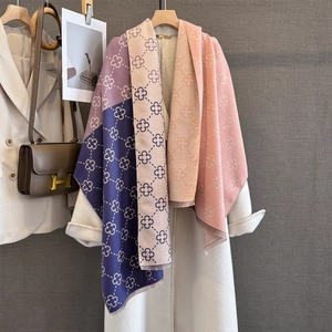 Detail of color-block scarf featuring four-leaf clover patterns and fine fringe