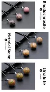 Detailed view of 14mm round crystal ball pendants in unakite and rhodochrosite stones