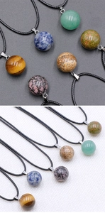 Detailed macro view of 14mm natural crystal sphere pendants in tiger eye and aventurine