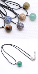 Macro detail of 14mm natural crystal ball pendants with adjustable black woven cord