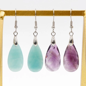 Faceted amethyst and amazonite teardrop crystal earrings on a gold display stand