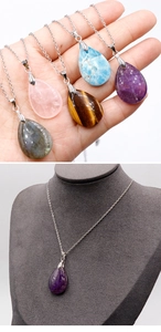 Macro detail of teardrop natural amethyst and agate stone pendants on silver chains
