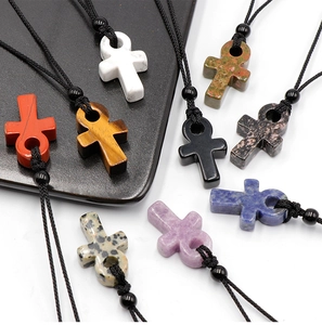 Vue détaillée des pendentifs croix Ankh faits main en diverses pierres naturelles de soin