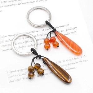 Water drop natural tiger eye and agate stone keychains on vintage book background