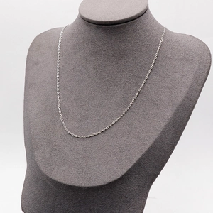 Polished silver cable chain necklace displayed on a minimalist grey neck bust model