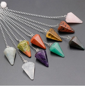 Close-up of hexagonal crystal prisms with silver chains in various natural gemstones