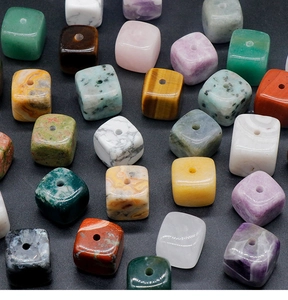 Macro shot of polished square natural stone beads with central holes for DIY jewelry