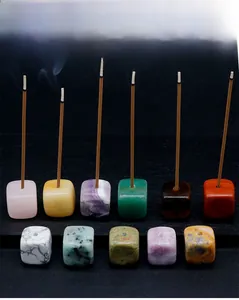 Macro shot of natural crystal and agate cube incense holders with burning incense sticks