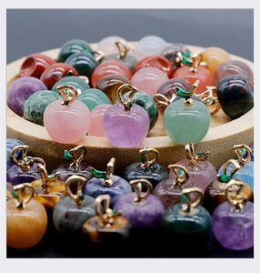 Macro shot of colorful apple-shaped natural stone pendants with gold leaf metal bails