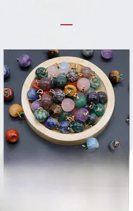 Macro shot of assorted natural crystal apple pendants with gold leaves on wooden tray