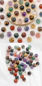 Detailed view of colorful apple-shaped stone pendants with gold loops and green leaves