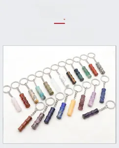 Macro detail of various natural gemstone keychains carved in bamboo shape with metal rings