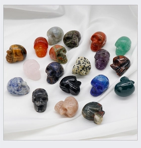 Detailed view of various natural crystal skull carvings in tiger eye and amethyst