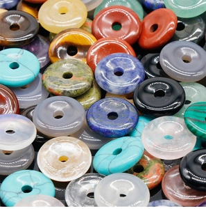 Macro shot of colorful polished gemstone donut beads including tiger eye and agate