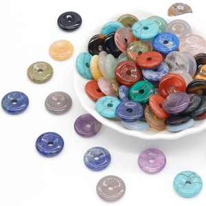 Mixed natural gemstone donut beads for DIY jewelry making in a white ceramic bowl