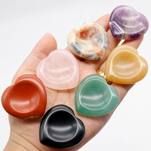 Set of seven heart-shaped polished natural crystal worry stones held in hand