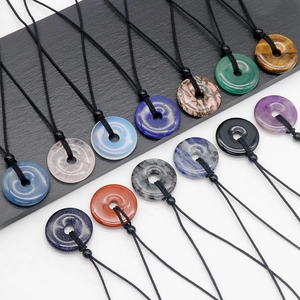Natural amethyst and gemstone donut necklaces with woven rope shown on stone slabs