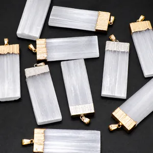 Dettaglio macro di ciondoli in selenite con bordi elettroplaccati in oro e argento