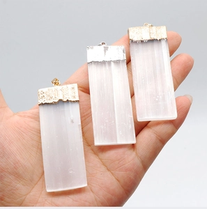 Macro shot of three selenite crystal pendants with gold and silver electroplated edges