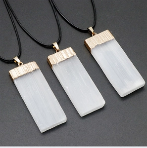 Detail of natural white gypsum stone pendants with elegant gold plated edges and cord