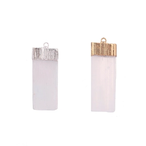 Natural selenite crystal pendants with gold and silver plated edges on white background