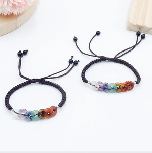 Détail des perles en pierre naturelle des 7 chakras tissées sur cordons marrons ajustables