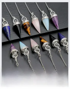 Detailed arrangement of hexagonal crystal pendulums with silver chains on black texture