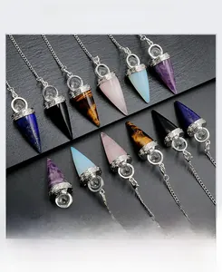 Detailed macro view of assorted natural crystal pendulum pendants with silver metal chains