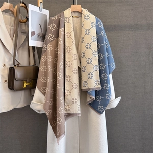 Detailed view of the double-sided floral pattern and soft fringes on a warm scarf