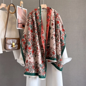 Close-up of beige pashmina shawl with red floral print and dark green piped edges