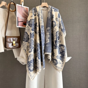 Elegant cream and blue floral peony jacquard shawl scarf draped over a white wool coat