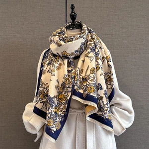 Detail of vintage floral scarf with navy blue borders and elegant tassels on a mannequin