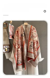 Detail of red paisley and houndstooth cashmere feel scarf styled with a white wool coat