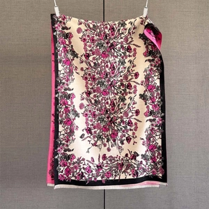 Detailed view of paisley cashmere-feel scarf featuring intricate pink floral prints and fringe