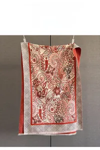 Close-up of red and beige paisley jacquard scarf showing fabric texture and fringe