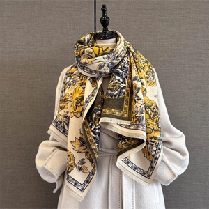 Vintage floral jacquard scarf in mustard and navy with tassels on an elegant coat