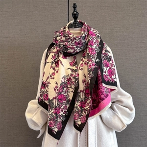 Close-up of floral cashmere-feel shawl with vintage patterns and tassel edge details
