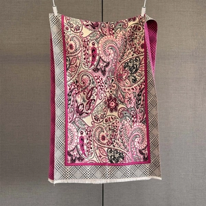 Detail of pink paisley cashmere-feel scarf showing intricate floral patterns and soft tassels