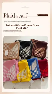 Detailed view of checkered cashmere-feel scarves with fringed edges in various colors