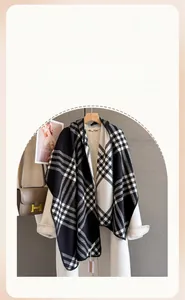 Detailed view of soft black and white plaid scarf paired with elegant beige coat