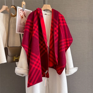 Detail of red checkered cashmere-like scarf draped over a white coat on hanger